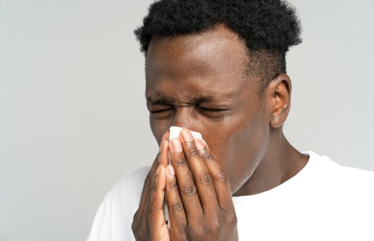 close-up-studio-portrait-of-young-african-man-with-napkin-sneezing-isolated-on-grey-white-background_t20_E0k6n1-112606_1047x675